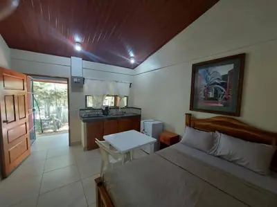 a bedroom with a bed and a table and a kitchen at Sol de la India - Pueblo Nuevo in Pueblo Nuevo