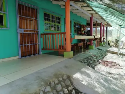 a green building with a table in front of it at Sol de la India - Pueblo Nuevo in Pueblo Nuevo