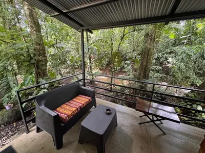 a screened in porch with a chair and a table at The frog house in Fortuna