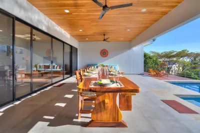 a long wooden table in a room with a pool at Casa Ojos Azules, Nosara. New Listing in Nosara