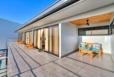 a balcony with chairs and tables on a building at Casa Ojos Azules, Nosara. New Listing in Nosara