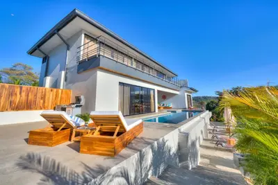 a villa with a swimming pool and a house at Casa Ojos Azules, Nosara. New Listing in Nosara