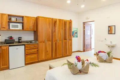 a kitchen with wooden cabinets and a table with flowers on it at Residencias Samara in Sámara