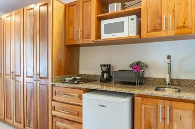 a kitchen with wooden cabinets and a white refrigerator at Residencias Samara in Sámara