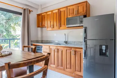 a kitchen with a table and a refrigerator at Residencias Samara in Sámara