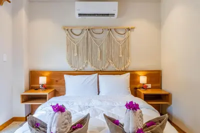 a bedroom with a white bed with flowers in baskets at Residencias Samara in Sámara