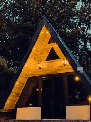 a house with a triangular roof at night at Pozas y Cascadas La Presa Habitación 1 in Río Cuarto