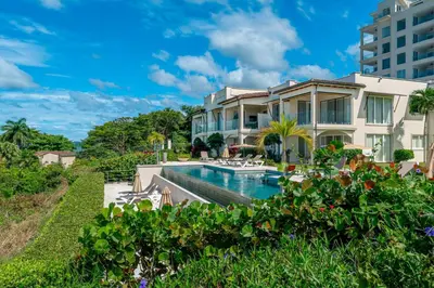 a house with a swimming pool next to a building at La Vista 2 - Diriá Tamarindo in Tamarindo