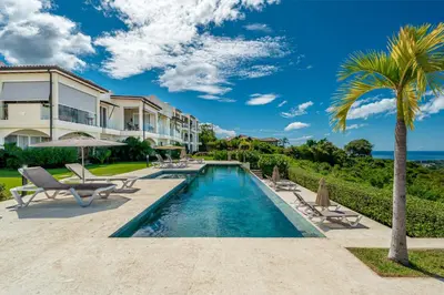 a villa with a swimming pool and a palm tree at La Vista 2 - Diriá Tamarindo in Tamarindo