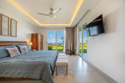 a bedroom with a bed and a flat screen tv at La Vista 2 - Diriá Tamarindo in Tamarindo
