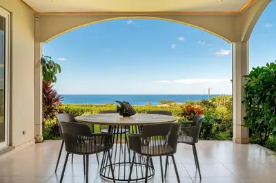 a patio with a table and chairs and the ocean at La Vista 2 - Diriá Tamarindo in Tamarindo