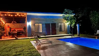 a backyard with a swimming pool at night at Apartamento Entero El Guanacaste con Piscina Compartida in Santa Cruz