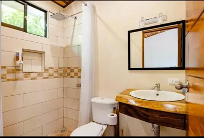 a bathroom with a sink and a toilet and a mirror at Apartamento Entero El Guanacaste con Piscina Compartida in Santa Cruz