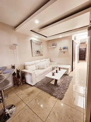 a living room with a white couch and a table at Apartamento SamSay I in Cartago