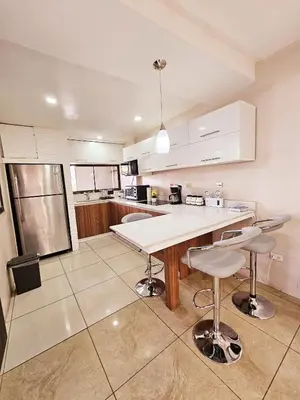 a kitchen with a table and two stools at Apartamento SamSay I in Cartago
