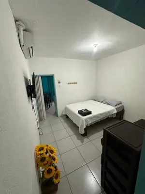 a bedroom with a bed and flowers in a room at Tourquesa Excellent WiFi Private in Liberia