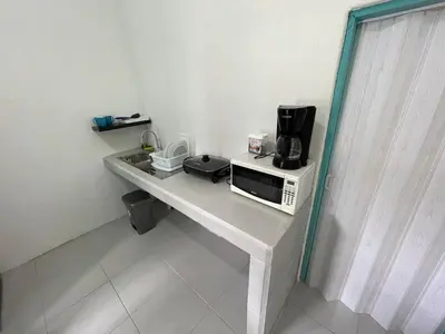 a table with a microwave and a coffee maker on it at Tourquesa Excellent WiFi Private in Liberia