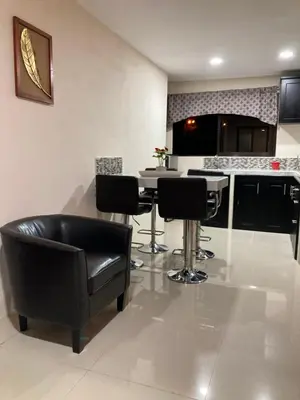 a kitchen with black chairs and a table in a room at Hospedaje Ana Lu 2, Only 10 minutes from airport in Alajuela City