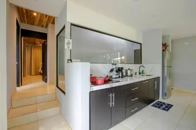 a kitchen with black cabinets and a large window at River Paradise Villa With Private Jacuzzi in Fortuna