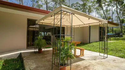 a building with a tent in front of a house at River Paradise Villa With Private Jacuzzi in Fortuna