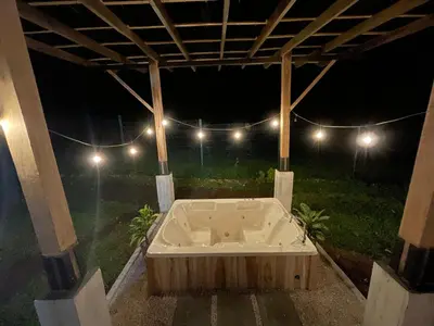 a bath tub in a backyard at night at River Paradise Villa With Private Jacuzzi in Fortuna
