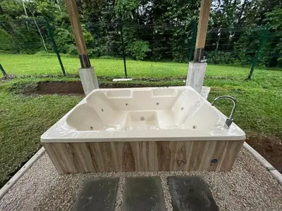 a large bath tub sitting in the middle of a yard at River Paradise Villa With Private Jacuzzi in Fortuna