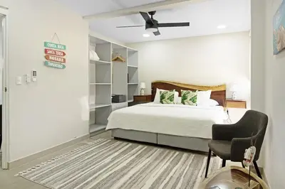 a bedroom with a bed and a chair at Modern 4BR Home, Pool, Parking, Walk To The Beach in Playa Flamingo