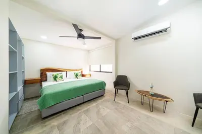 a bedroom with a green bed and a table at Modern 4BR Home, Pool, Parking, Walk To The Beach in Playa Flamingo