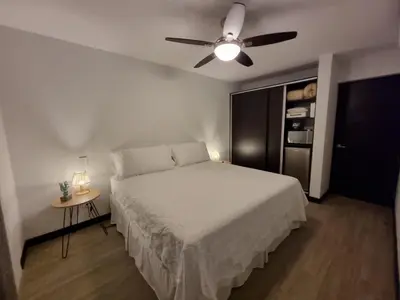 a bedroom with a bed and a ceiling fan at Casa Cardumen - Ciudad Del Mar, in Jaco in Jacó