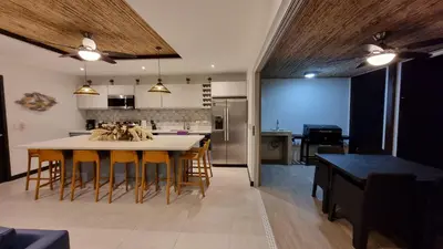 a kitchen and dining room with a table and chairs at Casa Cardumen - Ciudad Del Mar, in Jaco in Jacó