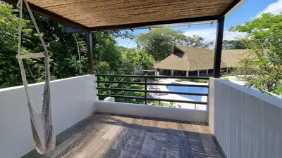 a view from the balcony of a house with a hammock at Casa Cardumen - Ciudad Del Mar, in Jaco in Jacó