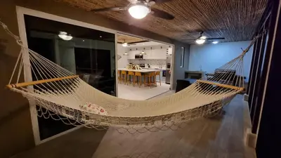 a hammock hanging from a wall in a room at Casa Cardumen - Ciudad Del Mar, in Jaco in Jacó