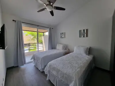 a bedroom with two beds and a ceiling fan at Casa Cardumen - Ciudad Del Mar, in Jaco in Jacó