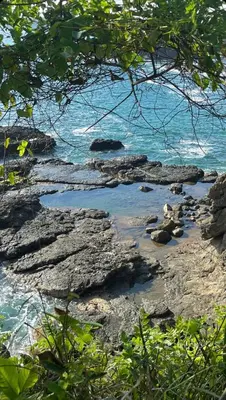 a view of a beach with rocks and the ocean at La Flor de Coco in Sámara