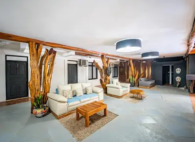 a living room with couches and tables and trees at La Flor de Coco in Sámara