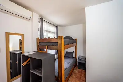 a small room with a bunk bed and a desk at La Flor de Coco in Sámara