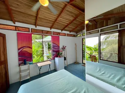 a bedroom with a bed and a room with a window at The Chorotega Hotel, Montezuma in Montezuma