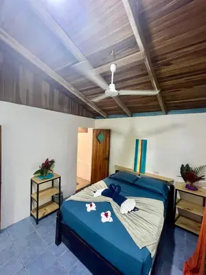 a bedroom with a blue bed and a wooden ceiling at The Chorotega Hotel, Montezuma in Montezuma
