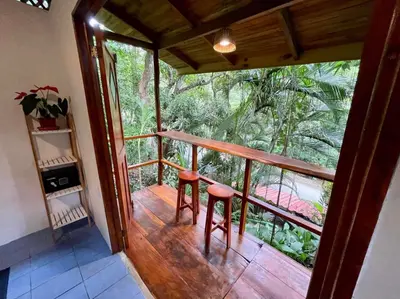 a room with a balcony with two stools at The Chorotega Hotel, Montezuma in Montezuma