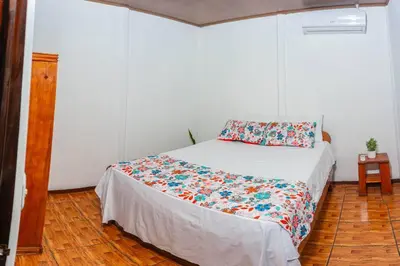 a bedroom with a bed with a floral comforter at Tony´s House #2 in Fortuna