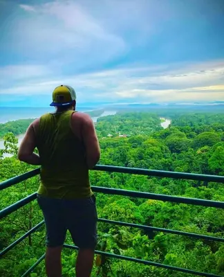 a man standing on top of a tower looking at the forest at Micheck beach house in Tortuguero