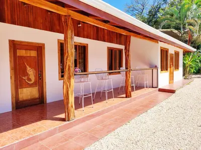 a house with a balcony with a wooden door at ICO Living Hostel in Santa Teresa Beach