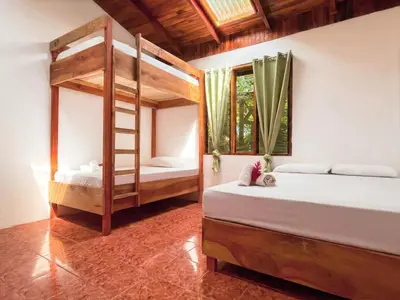 a bedroom with two bunk beds and a window at ICO Living Hostel in Santa Teresa Beach