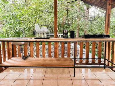a wooden deck with a bench on a porch at ICO Living Hostel in Santa Teresa Beach