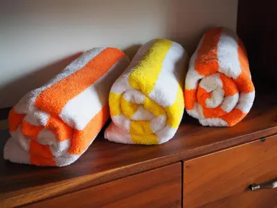three felted towels sitting on top of a wooden cabinet at Hacienda Las Vainillas Boutique Hotel in Mastatal