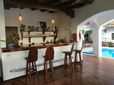 a bar with three stools at a counter in a room at Hacienda Las Vainillas Boutique Hotel in Mastatal