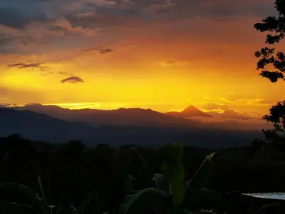 a sunset with mountains in the background at Cabaña Colibrí in Quesada
