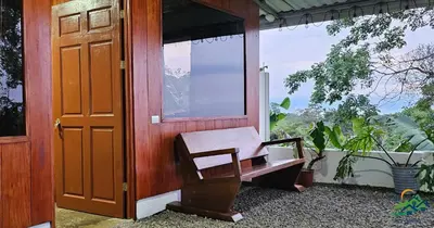 a porch with a chair next to a door at Cabaña Colibrí in Quesada