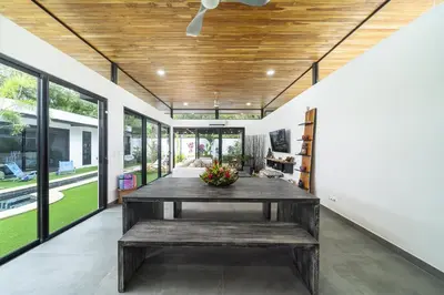 a living room with a wooden ceiling and a table at Playa Potrero - NEW modern house, pool in guitar shape - Casa Guitarra in Potrero