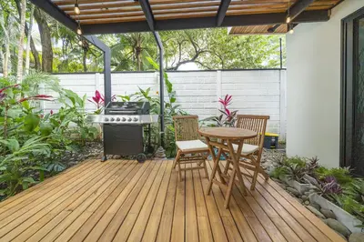 a patio with a table and chairs on a wooden deck at Playa Potrero - NEW modern house, pool in guitar shape - Casa Guitarra in Potrero